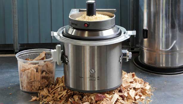Pressure cooker with a container of wood chips inside.